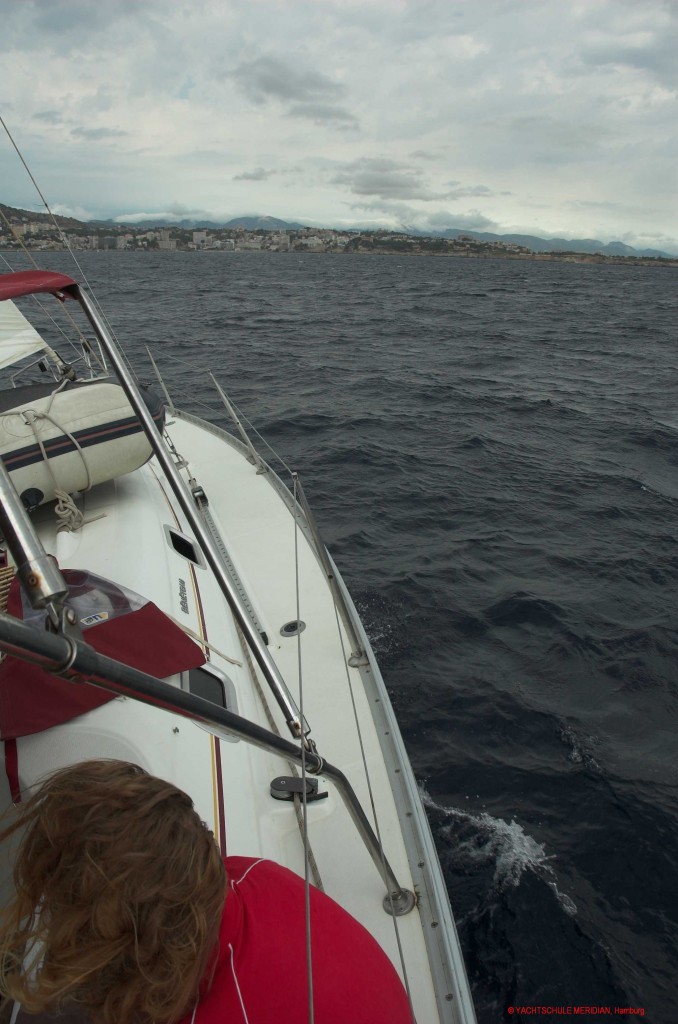 Segelyacht am Wind uns achteraus die Küste